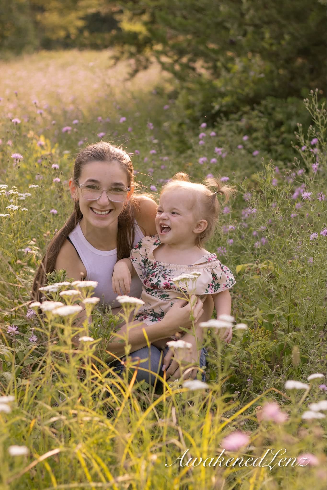 A woman and her laughing toddler niece in tall summer grass