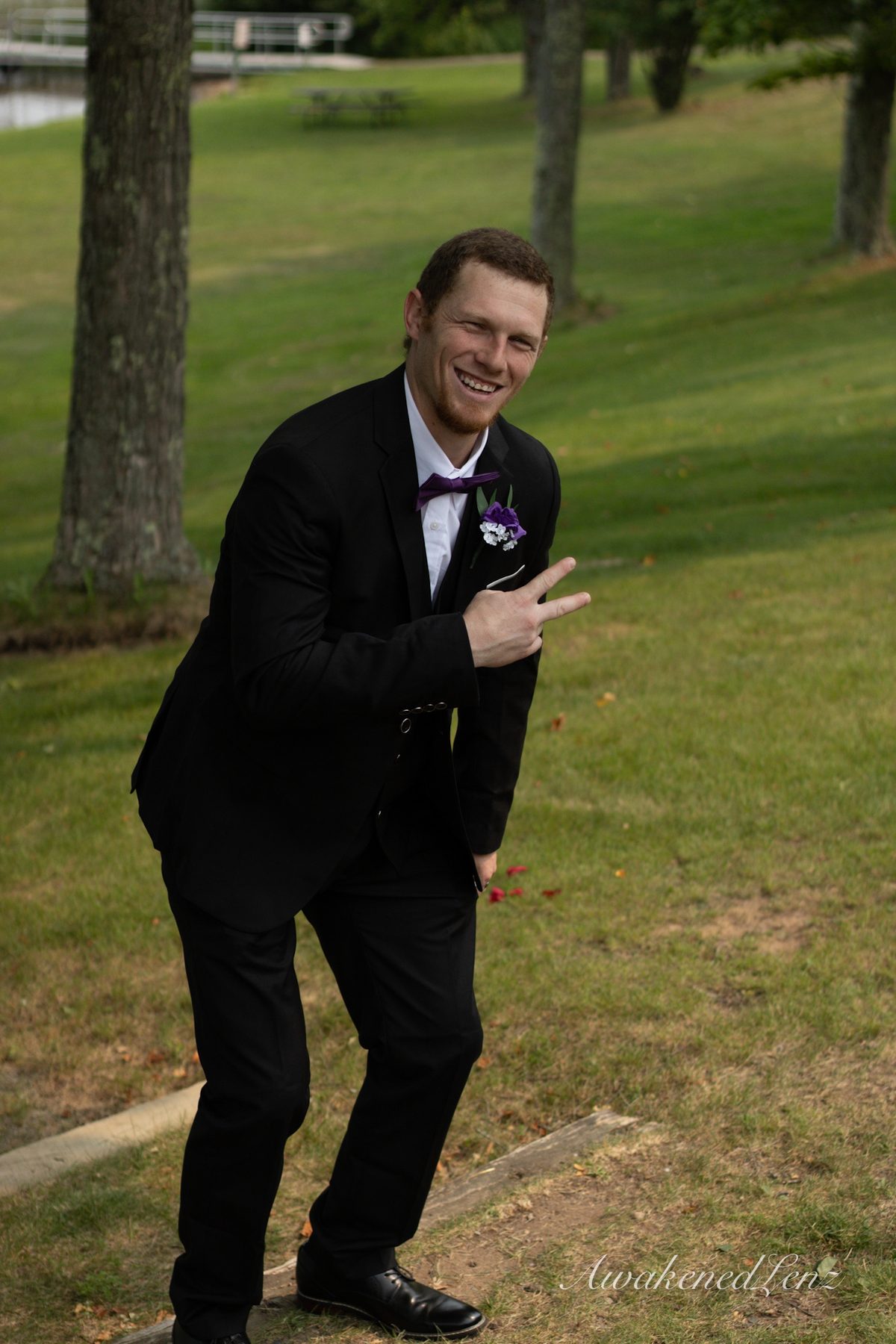 A groom leaning into the frame and pointing at the camera