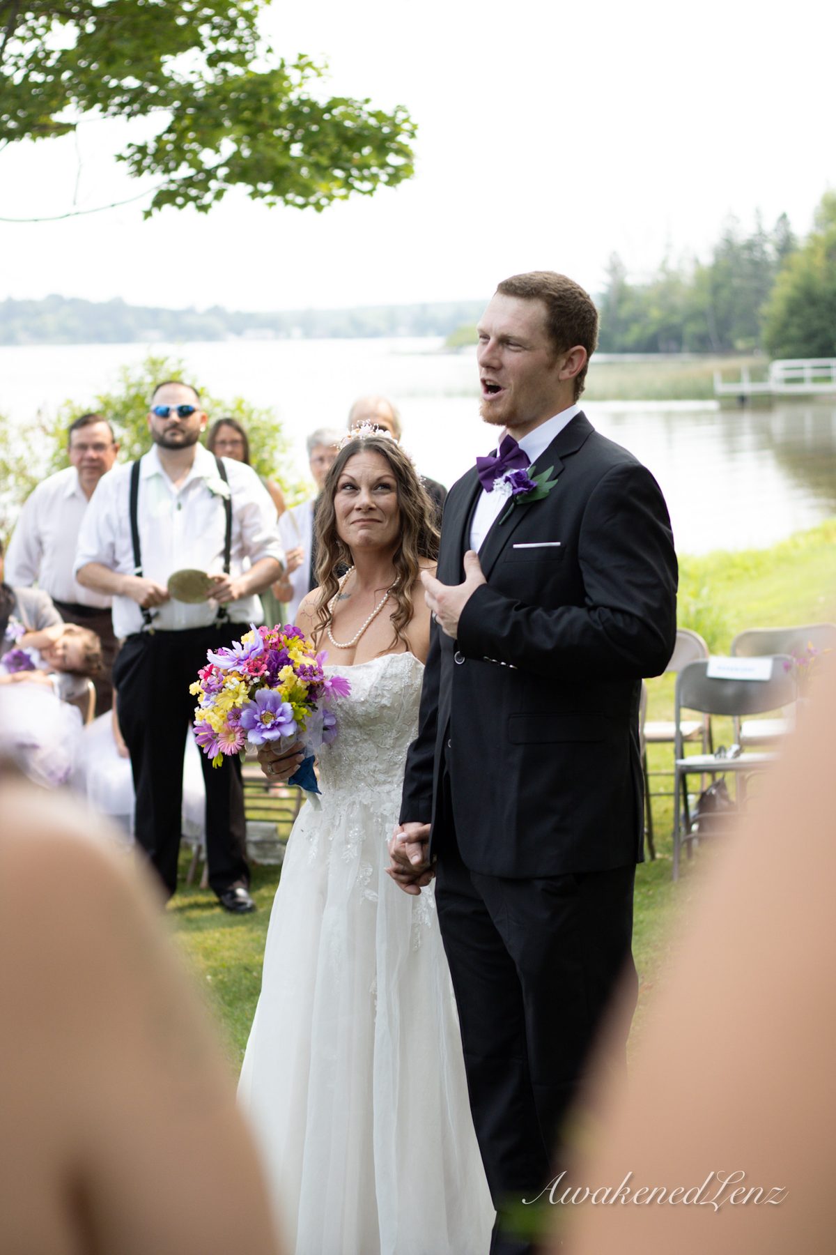 A bride and groom at the altar during a lakeside ceremony