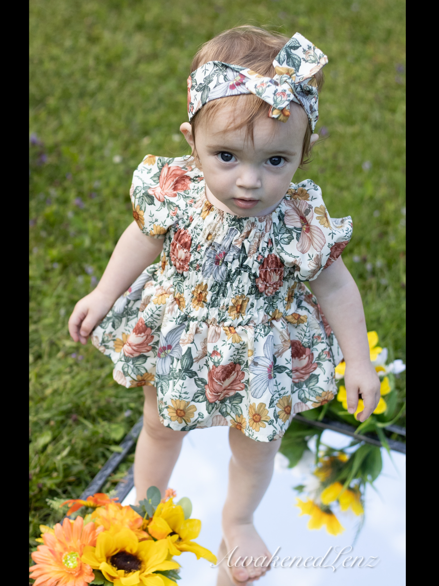 A small child photographed with cut sunflowers, frame 4 of 4
