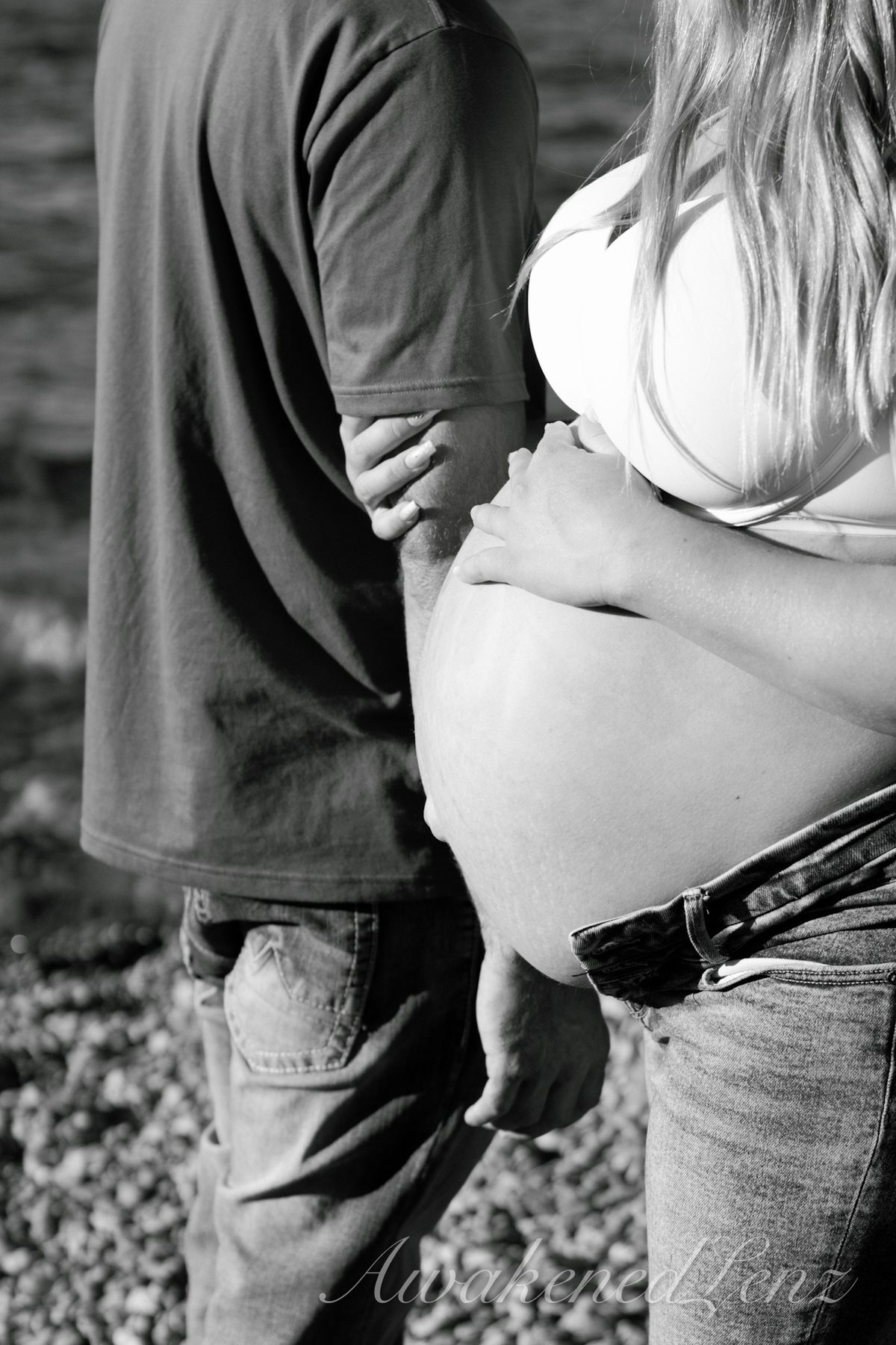 A maternity session on a rocky lakeshore at golden hour, frame 2 of 45