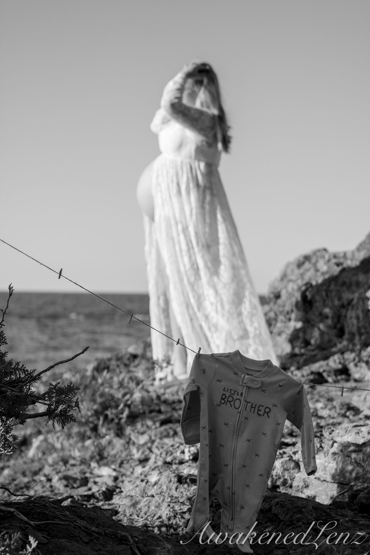 A maternity session on a rocky lakeshore at golden hour, frame 23 of 45