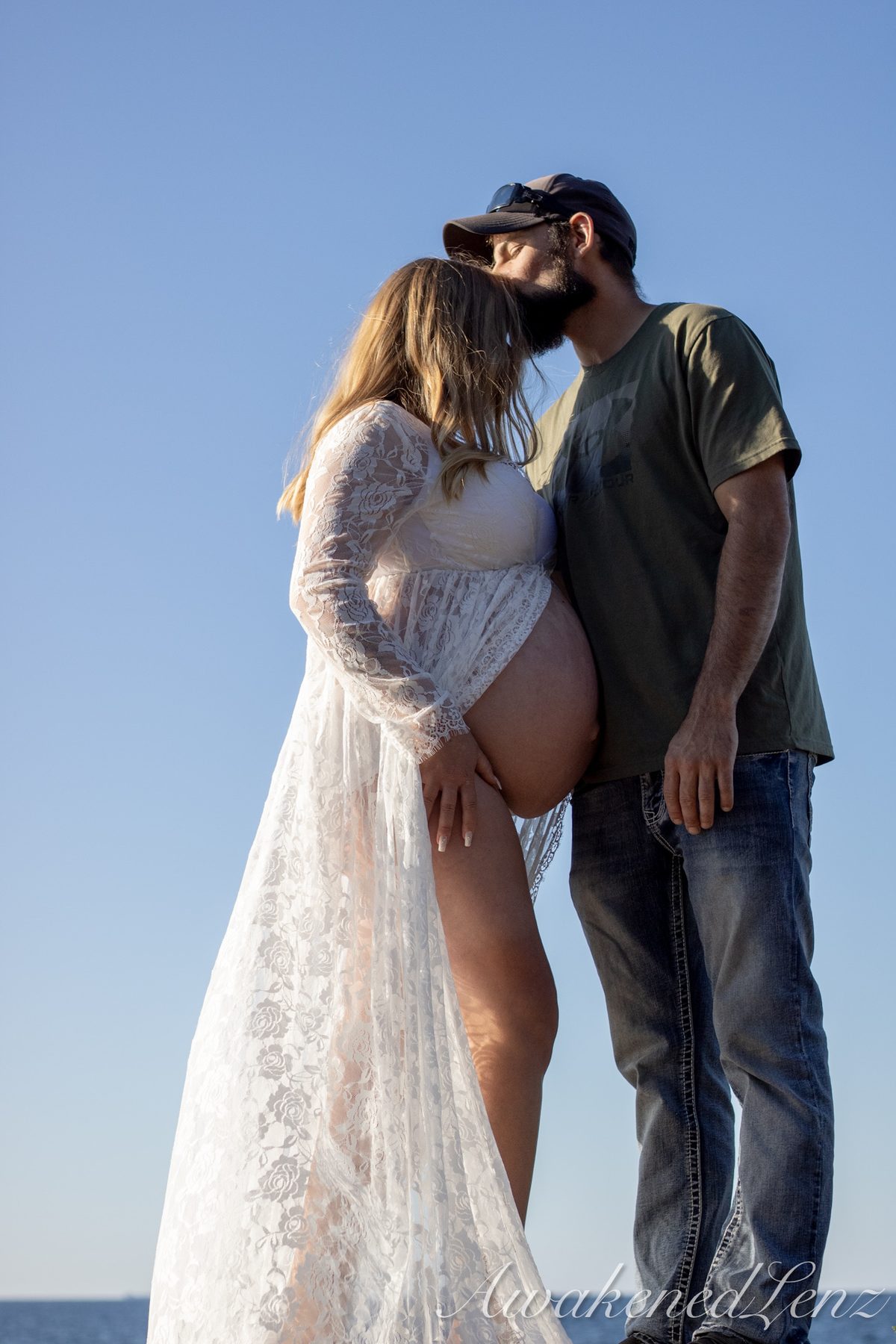 A maternity session on a rocky lakeshore at golden hour, frame 28 of 45