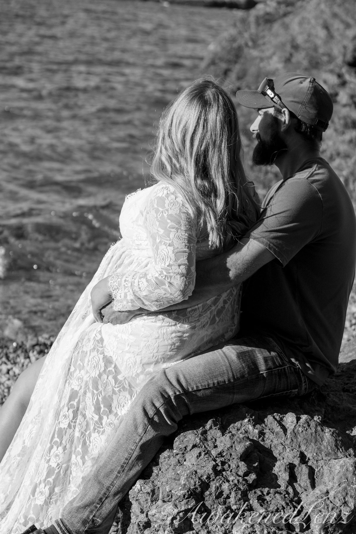 A maternity session on a rocky lakeshore at golden hour, frame 32 of 45