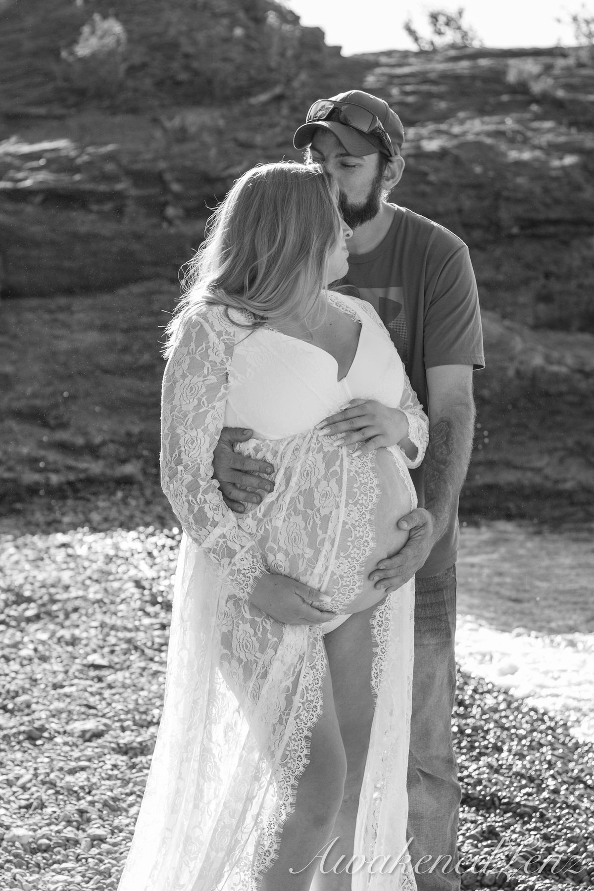 A maternity session on a rocky lakeshore at golden hour, frame 33 of 45