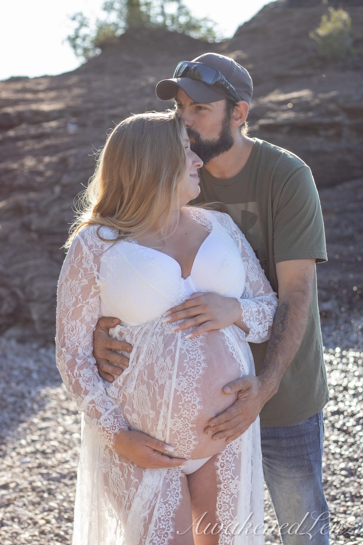 A maternity session on a rocky lakeshore at golden hour, frame 34 of 45