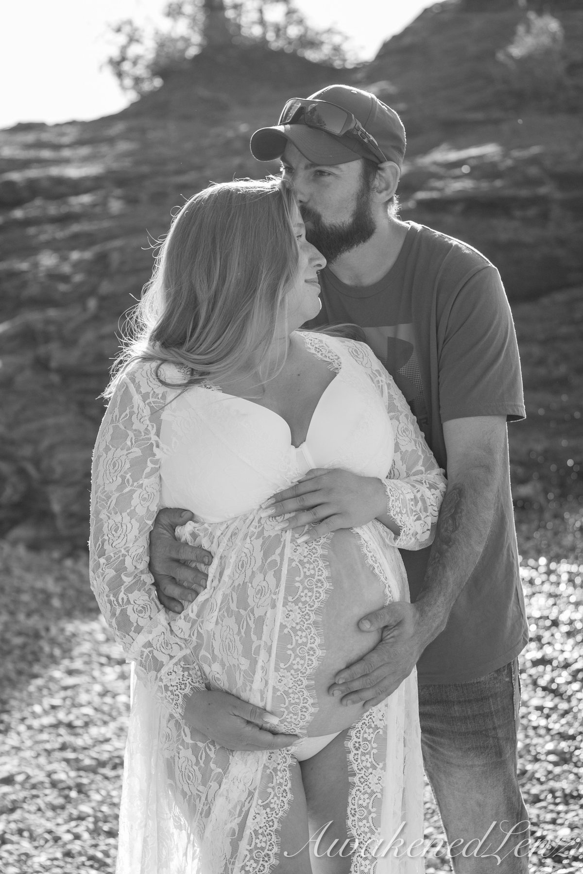 A maternity session on a rocky lakeshore at golden hour, frame 35 of 45
