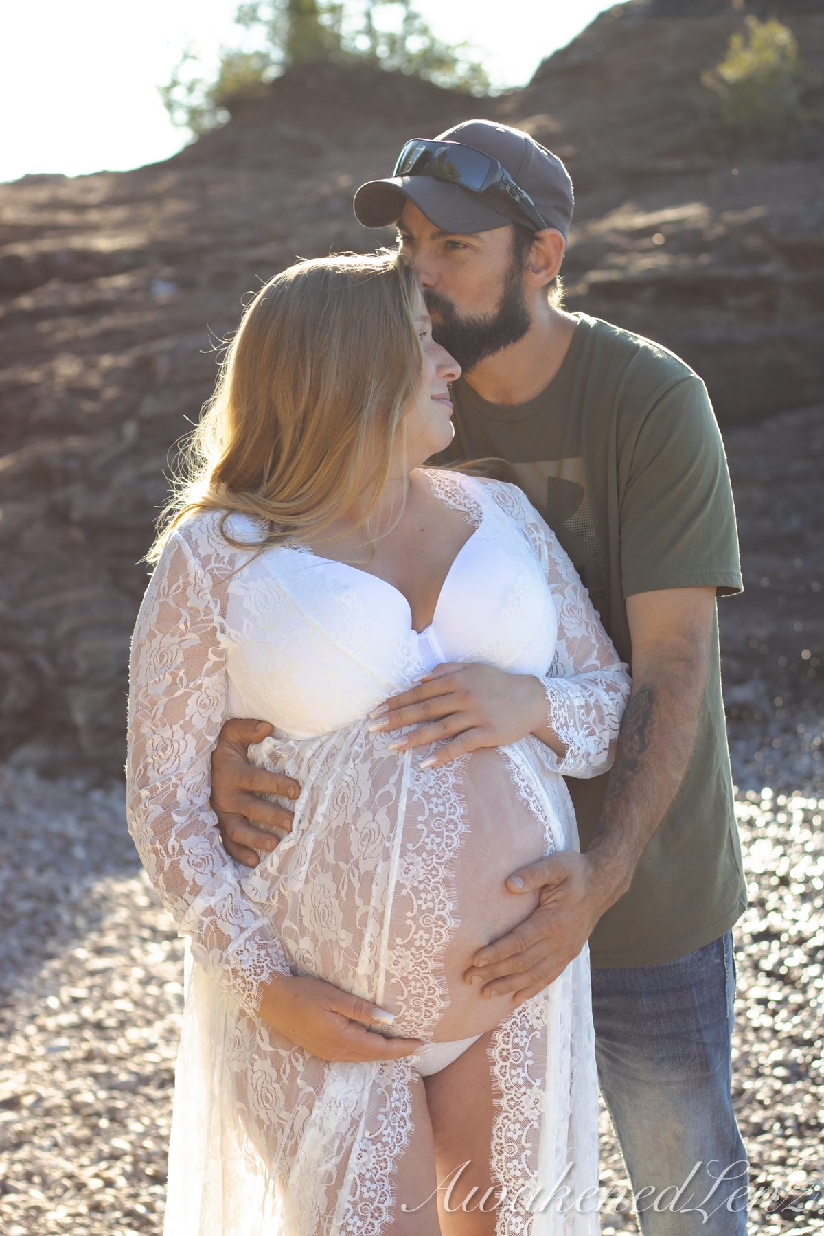 A maternity session on a rocky lakeshore at golden hour, frame 36 of 45